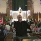 In this June 9, 2019 photo, Father Eduard Perrone conducts a choir during mass at Assumption of the Blessed Virgin March Parish in Detroit. The Roman Catholic Archdiocese of Detroit said Sunday, July 7 that it has removed Perrone from public ministry after receiving what it described as a &amp;quot;credible allegation&amp;quot; that he had abused a child decades ago. (AP Photo/Paul Sancya)