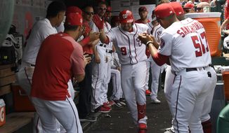 Washington Nationals&#39; Brian Dozier (9) celebrates his home run in the dugout with his teammates during the second inning of a baseball game against the Kansas City Royals, Sunday, July 7, 2019, in Washington. The Nationals won 5-2. (AP Photo/Nick Wass)