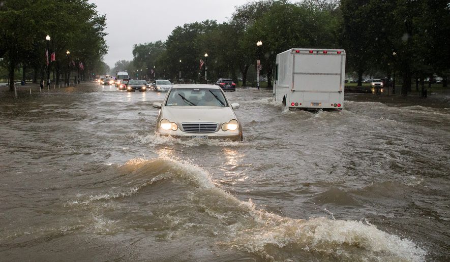 Heavy rainfall flooded the intersection of 15th Street and Constitution Avenue Northwest and stalled cars in the street on Monday in the District. A slow moving weather system dumped 2 to 4 inches of rain. (Associated Press)