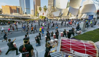 Members of the Venice Koshin Taiko drumming ensemble perform for Los Angeles Marathon runners as they race past the Walt Disney Concert Hall in Los Angeles Sunday, March 18, 2018. (AP Photo/Damian Dovarganes)