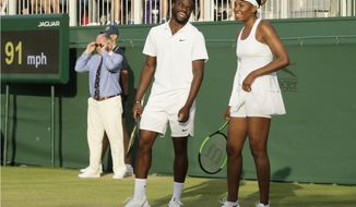 United States&#39;s Frances Tiafoe, left, and Venus Williams laugh during their Mixed Doubles match during day five of the Wimbledon Tennis Championships in London, Friday, July 5, 2019. (AP Photo/Tim Ireland)