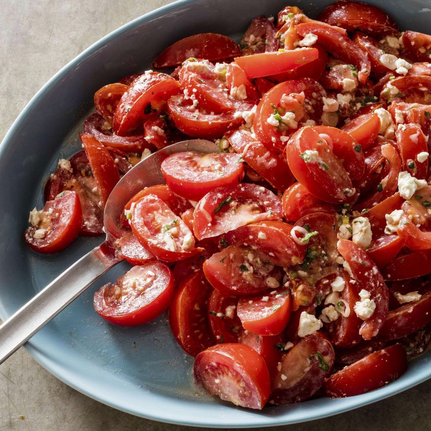 This undated photo provided by America's Test Kitchen in June 2019 shows a Tomato Salad with Feta and Cumin-Yogurt Dressing in Brookline, Mass. This recipe appears in "The Complete Mediterranean Cookbook." (Daniel J. van Ackere/America's Test Kitchen via AP)