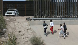 Asylum seekers cross the border between El Paso, Texas, and Ciudad Juarez, Mexico, on Thursday. (Associated Press)