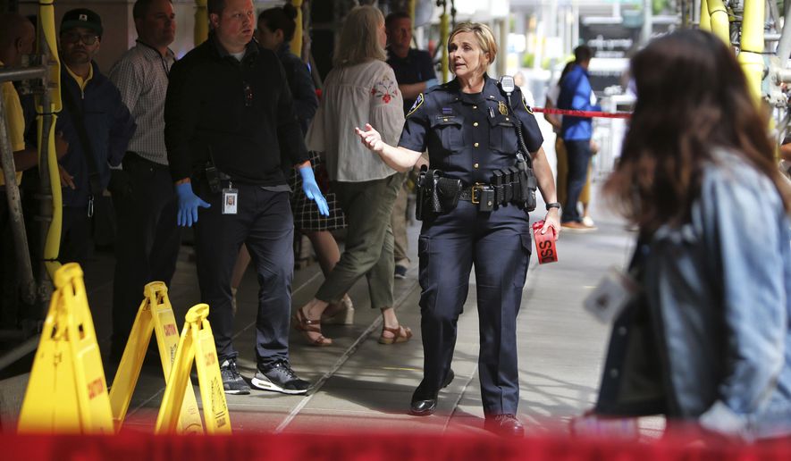 Police investigate a crime scene outside of Nordstrom, where a man reportedly stabbed several people in the morning on the sidewalk, Tuesday, July 9, 2019, in downtown Seattle. Police say a suspect is in custody. Streets were closed near the scene as the investigation continues. (AP Photo/seattlepi.com, Genna Martin)