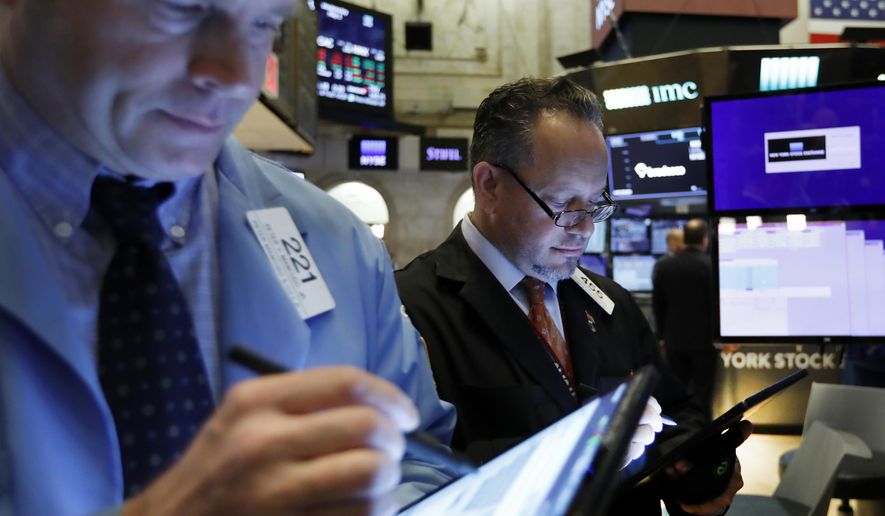 FILE - In this May 1, 2019, file photo traders Peter Mancuso, left, and Robert Arciero work on the floor of the New York Stock Exchange. The U.S. stock market opens at 9:30 a.m. EDT on Tuesday, July 9. (AP Photo/Richard Drew, File)