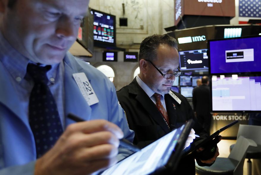 FILE - In this May 1, 2019, file photo traders Peter Mancuso, left, and Robert Arciero work on the floor of the New York Stock Exchange. The U.S. stock market opens at 9:30 a.m. EDT on Tuesday, July 9. (AP Photo/Richard Drew, File)