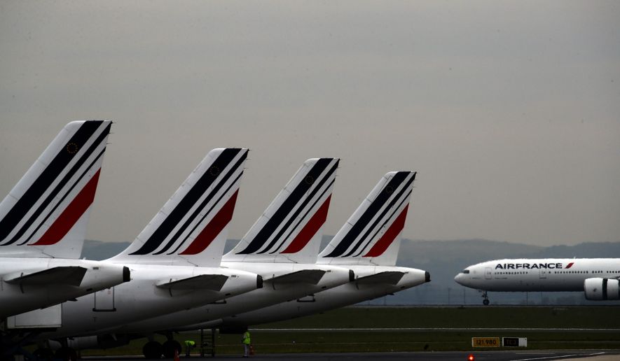 FILE - In this May 17, 2019 file photo, Air France planes are parked on the tarmac at Paris Charles de Gaulle airport, in Roissy, near Paris. The French government will implement an "ecotax" on plane tickets for flights departing from France from next year, the government said Tuesday July 9, 2019. The tax is expected to raise over 180 million euros ($200 million) from 2020 to invest in eco-friendly transport infrastructure, including rail. (AP Photo/Christophe Ena, File)