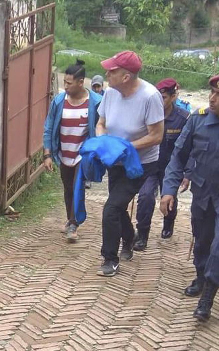 In this Monday, July 8, 2019 photo, Canadian aid worker Peter Dalglish, center wearing red cap, is brought to appear before the Kavre District Court in Nepal. Dalglish was Monday sentenced to nine years in prison in Nepal for sexually abusing two boys who were found at his home. (AP Photo/ Janak Raj Sapkota)