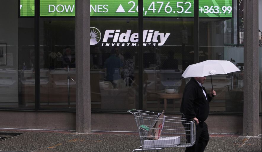 In this June 18, 2019, file photo, a man pulls a grocery cart as he walks in the rain past the stock ticker scroll board, showing a strong daily gain in the Dow Jones, outside Fidelity Investments in the Financial District of Boston. According to a survey by The Associated Press-NORC Center for Public Affairs Research, Americans are generally satisfied with their personal finances, but many lack confidence in their ability to afford retirement, an emergency expense or even their daily living costs (AP Photo/Charles Krupa)