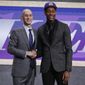 FILE - In this Thursday, June 20, 2019, file photo, Virginia&#39;s De&#39;Andre Hunter, right, is greeted by NBA Commissioner Adam Silver after being selected with the fourth pick overall by the Los Angeles Lakers during the NBA basketball draft in New York. Hunter went No. 4 overall, taken by the Los Angeles Lakers. His rights had been traded twice, first to New Orleans as part of the Anthony Davis deal, then to Atlanta. But since neither of those trades could be closed before July 6, Hunter wore a Lakers cap on stage. Silver wants the hat game fixed. (AP Photo/Julio Cortez, File)