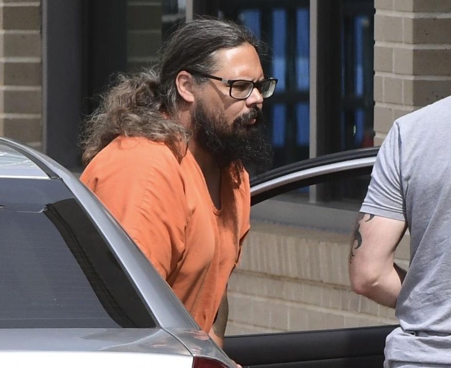 Michael Lambert Seabrooke, the Pickens County courthouse bombing suspect, is escorted from a car to the federal courthouse in Greenville, S.C., Wednesday, July 10, 2019. Federal agents say Seabrooke, who allegedly exploded two bombs outside the Pickens County courthouse, had his lawsuit about poor jail conditions in the same county thrown out just days earlier. (Ken Ruinard/The Independent-Mail via AP)
