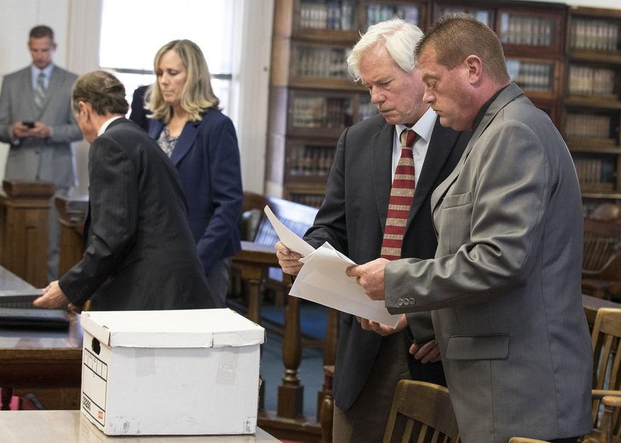 Pike County Sheriff Charles Reader, right, talks with his lawyer James T. Boulger after his arraignment, Tuesday, July 2, 2019, at the Pike County Courthouse in Waverly, Ohio. Reader plead not guilty to charges including felony evidence-tampering and theft in office after authorities investigated an anonymous complaint that he stole money seized in drug cases. (Robert McGraw/The Chillicothe Gazette via AP)