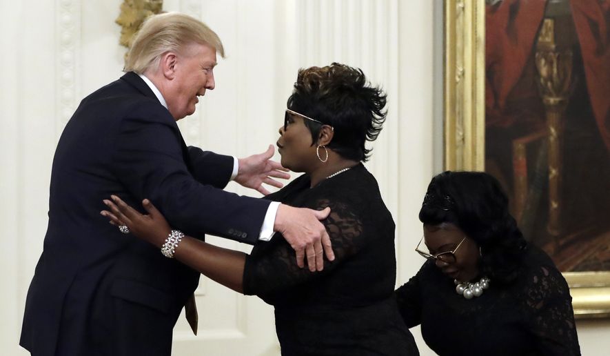 President Donald Trump hugs &quot;Diamond and Silk&quot; during the &quot;Presidential Social Media Summit&quot; in the East Room of the White House, Thursday, July 11, 2019, in Washington. (AP Photo/Evan Vucci)