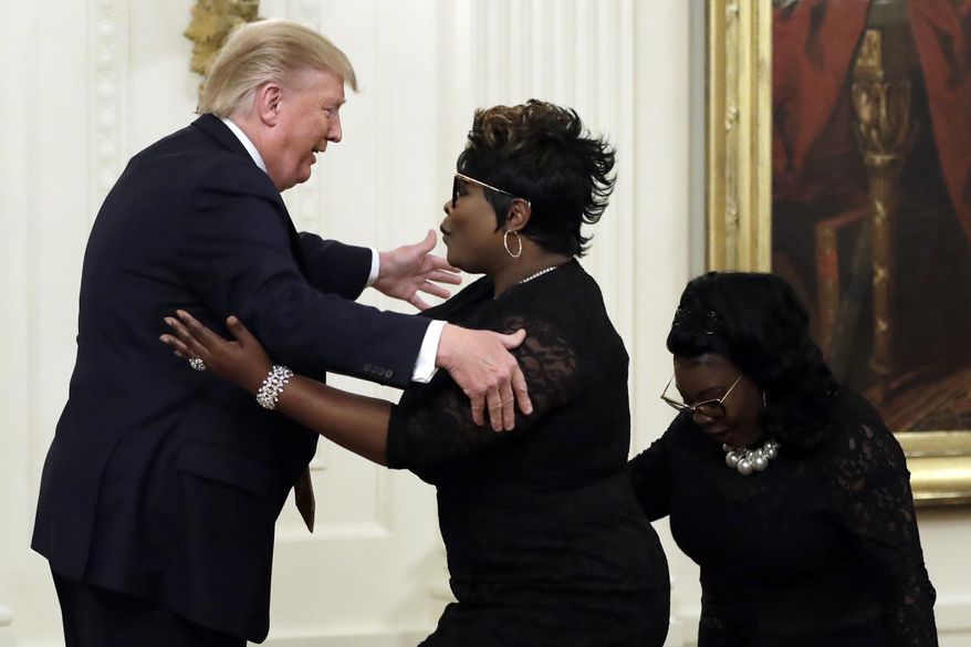 President Donald Trump hugs &quot;Diamond and Silk&quot; during the &quot;Presidential Social Media Summit&quot; in the East Room of the White House, Thursday, July 11, 2019, in Washington. (AP Photo/Evan Vucci)