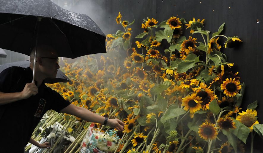 Attendees take part in a public memorial for Marco Leung, the 35-year-old man who fell to his death weeks ago after hanging a protest banner against an extradition bill, in Hong Kong, Thursday, July 11, 2019. The parents of Leung have urged young people to stay alive to continue their struggle. (AP Photo/Kin Cheung)