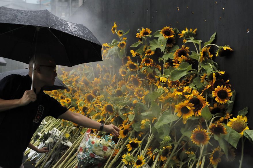 Attendees take part in a public memorial for Marco Leung, the 35-year-old man who fell to his death weeks ago after hanging a protest banner against an extradition bill, in Hong Kong, Thursday, July 11, 2019. The parents of Leung have urged young people to stay alive to continue their struggle. (AP Photo/Kin Cheung)