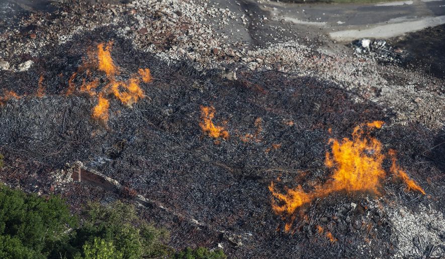 FILE - In a Wednesday, July 3, 2019 file photo, flames and smoke rise from a bourbon warehouse fire at a Jim Beam distillery in Woodford County, Ky. Bourbon that leaked from the fire that destroyed a Jim Beam barrel warehouse in Kentucky is making its way to the Ohio River. The Kentucky Energy and Environment Cabinet says in a release on social media that an “alcohol plume” from the bourbon runoff in the Kentucky River is approximately 23 miles (37 kilometers) long. (Pat McDonogh/Courier Journal via AP, File)
