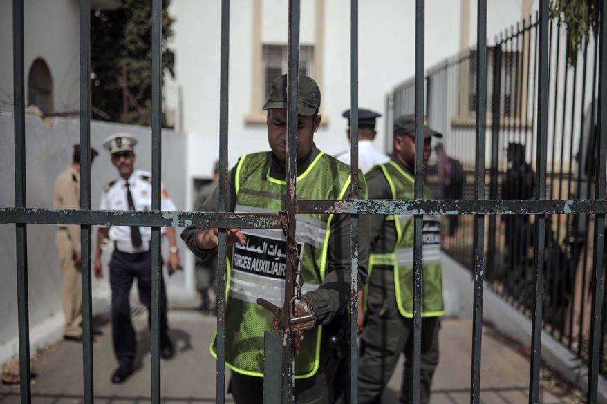 Security forces stand guard as suspects charged in connection with the killing of two Scandinavian tourists in Morocco's Atlas Mountains, arrive to a trial session in Sale, near Rabat, Morocco, Thursday, July 11, 2019. Nearly two dozen people, suspected killers and accomplices, appeared in court on terrorism charges for the brutal slayings last December of two Scandinavian women hikers. (AP Photo/Mosa'ab Elshamy)