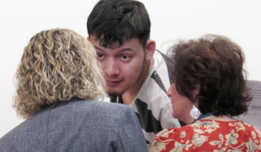 FILE - In this Jan. 24, 2019 file photo, Wilber Ernesto Martinez-Guzman, of El Salvador, talks to his public defender and interpreter during his initial appearance in Carson City Justice Court in Carson City, Nev. Lawyers for the Salvadoran immigrant accused of killing four Nevadans are asking the state Supreme Court to overturn a judge's ruling upholding a grand jury's authority to indict him in Reno for two of the fatal shootings outside the county. Public defenders for Martinez Guzman want the high court to dismiss two counts each of murder with a deadly weapon and burglary in the January deaths of Connie Koontz and Sophia Renken in Douglas County south of Carson City. (AP Photo/Scott Sonner, File)