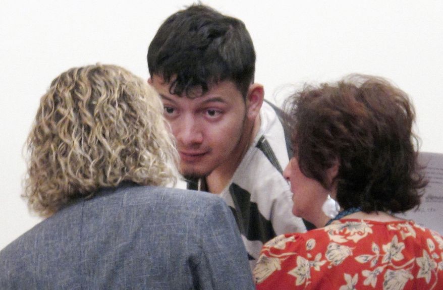 FILE - In this Jan. 24, 2019 file photo, Wilber Ernesto Martinez-Guzman, of El Salvador, talks to his public defender and interpreter during his initial appearance in Carson City Justice Court in Carson City, Nev. Lawyers for the Salvadoran immigrant accused of killing four Nevadans are asking the state Supreme Court to overturn a judge's ruling upholding a grand jury's authority to indict him in Reno for two of the fatal shootings outside the county. Public defenders for Martinez Guzman want the high court to dismiss two counts each of murder with a deadly weapon and burglary in the January deaths of Connie Koontz and Sophia Renken in Douglas County south of Carson City. (AP Photo/Scott Sonner, File)