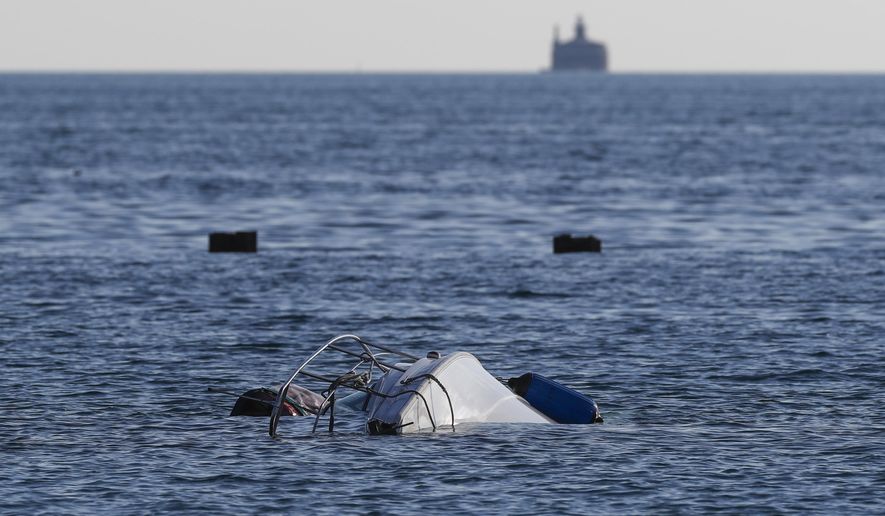 A boat remains upside down in the water south of West Fullerton Parkway at the lakefront in Chicago, Thursday, July 11, 2019. Authorities say one person died and two were rescued after the sailboat capsized early Thursday in Lake Michigan. (Jose M. Osorio/Chicago Tribune via AP)