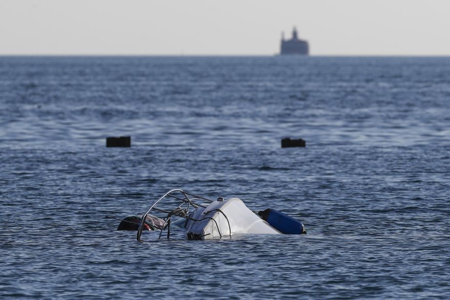 A boat remains upside down in the water south of West Fullerton Parkway at the lakefront in Chicago, Thursday, July 11, 2019. Authorities say one person died and two were rescued after the sailboat capsized early Thursday in Lake Michigan. (Jose M. Osorio/Chicago Tribune via AP)