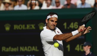 Switzerland&#39;s Roger Federer returns to Spain&#39;s Rafael Nadal in a Men&#39;s singles semifinal match on day eleven of the Wimbledon Tennis Championships in London, Friday, July 12, 2019. (Adrian Dennis/Pool Photo via AP)