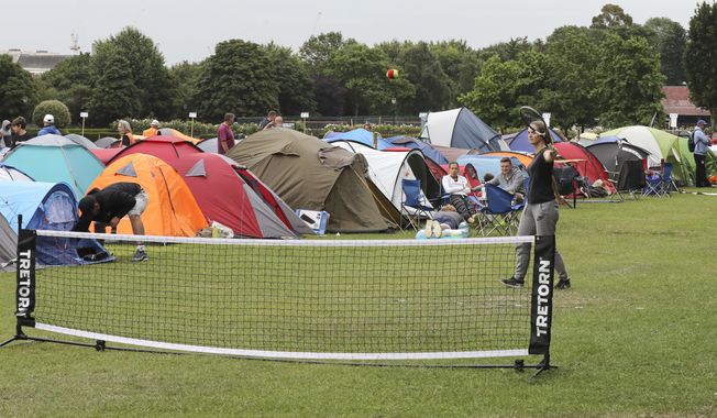 In this Tuesday, July 9, 2019, some tennis fans play a game as they wait in line for tickets to enter the Wimbledon Tennis Championships in London. For many the Wimbledon experience starts in a tent as they gather in a small park across from the tournament grounds to camp out, some for days, in the hope of getting a ticket to Centre Court as they are released each day. &amp;quot;The Queue&amp;quot; is a decades-old tradition that has grown to become its own phenomenon.(AP Photo/Natasha Livingstone)
