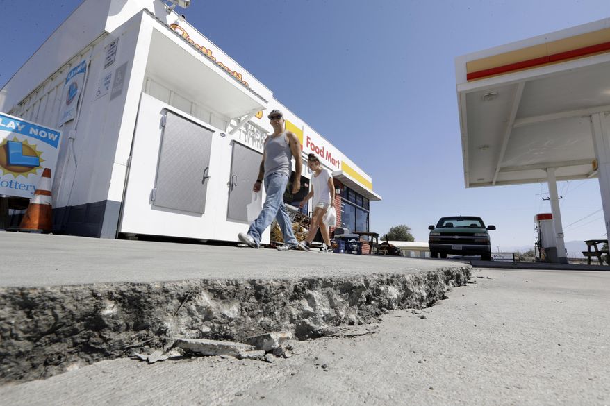FILE - This July 6, 2019 photo shows crack in a gas station's driveway in the aftermath of an earthquake in Trona, Calif. Officials say Thursday, July 11, 2019, that two Southern California desert communities, Ridgecrest and Trona, struck by last week's powerful earthquakes may have sustained as little damage as they did because they have no tall buildings and many homes are fairly new and built to strict earthquake standards. Nearby Trona, with a population of about 2,000, was harder hit, and commissioners noted many of its buildings are older. (AP Photo/Marcio Jose Sanchez, File)