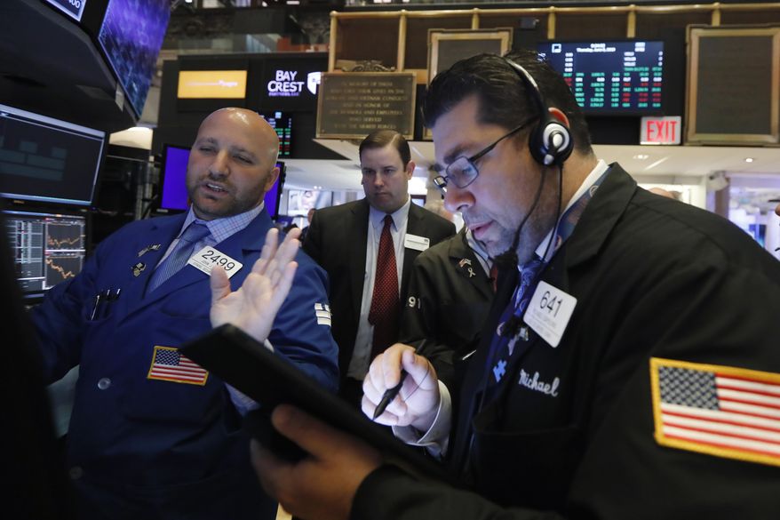 FILE - In this June 6, 2019, file photo specialist John Parisi, left, works with traders on the floor of the New York Stock Exchange. The U.S. stock market opens at 9:30 a.m. EDT on Friday, July 12. (AP Photo/Richard Drew, File)