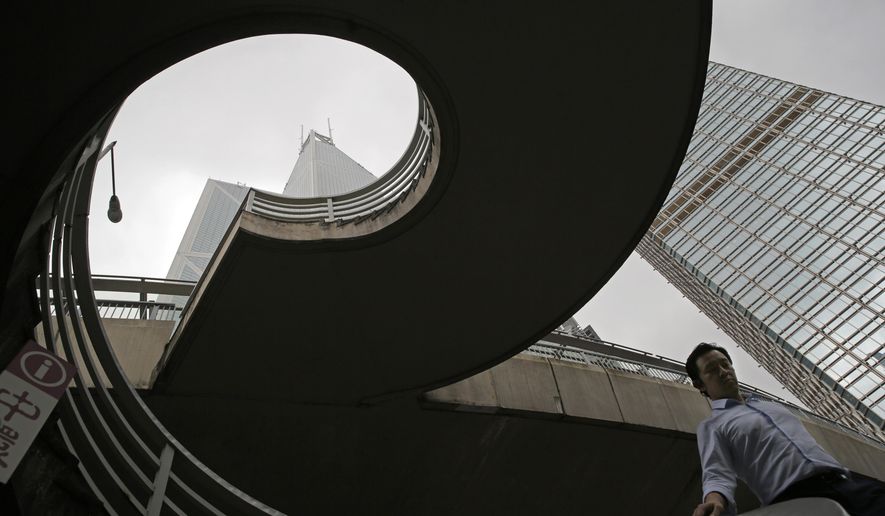 In this July 10, 2019, photo, a man walks on a bridge near the Bank of China Tower at Central, a business district of Hong Kong. It’s still the world’s “freest” economy, one of the biggest global financial centers and a scenic haven for tycoons and tourists, but the waves of protests rocking Hong Kong are exposing strains unlikely to dissipate as communist-ruled Beijing’s influence grows. (AP Photo/Kin Cheung)
