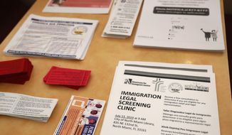 Flyers in English and Spanish are shown stacked at a nearby restaurant before immigration advocates gather them and hand them out, Thursday, July 11, 2019, in the Little Havana neighborhood in Miami. The Trump administration is moving forward with a nationwide immigration enforcement operation this weekend targeting migrant families. (AP Photo/Wilfredo Lee)