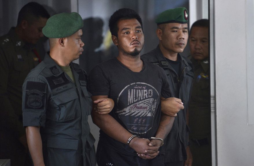 FILE - in this April 9, 2019, file photo, Thai suspect Ronnakorn Romruen, center, is escorted by police as he arrives at the Koh Sichang police station in Chonburi province, Thailand. Ronnakorn was sentenced to death Wednesday, July 10, 2019 by the Chonburi provincial court for raping and murdering a German tourist on the popular resort island after he confessed to carrying out the ordeal. (AP Photo, File)