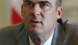 FILE - In this July 2, 2019 file photo, Oklahoma Gov. Kevin Stitt is pictured during an interview in Oklahoma City. Stitt suggested in an editorial Monday, July 8, in the Tulsa World that the compacts between the state and the tribes should be reevaluated since the industry has matured. (AP Photo/Sue Ogrocki, File)