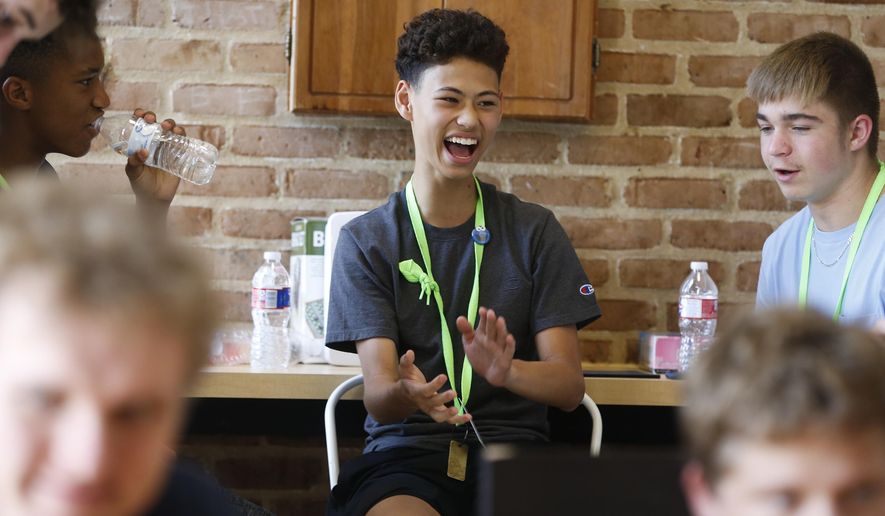 Charles Kimbrough, center, of Allen, Texas laughs while playing Monopoly with other students participating in part of a Duke University Talent Identification Program for high-achieving students at Rice University on Friday, July 12, 2019, in Houston. The students were evacuated from Louisiana State University to stay of out the path of Tropical Storm Barry. (Elizabeth Conley/Houston Chronicle via AP)