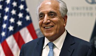 FILE - In this Feb. 8, 2019, file photo, Special Representative for Afghanistan Reconciliation Zalmay Khalilzad smiles at the U.S. Institute of Peace, in Washington. Amid talk of a U.S. troop withdrawal from Afghanistan, Khalilzad, the U.S. envoy talking to the Taliban said Thursday, July 11, that America is not “cutting and running” from its longest war and that women will continue to have seats in peace talks to end nearly 18 years of fighting. (AP Photo/Jacquelyn Martin, File)