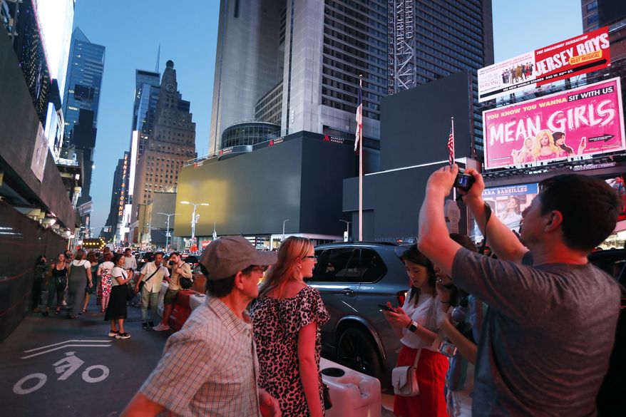 Screens in Times Square are black during a widespread power outage, Saturday, July 13, 2019, in New York. Authorities say a transformer fire caused a power outage in Manhattan and left businesses without electricity, elevators stuck and subway cars stalled. (AP Photo/Michael Owens)