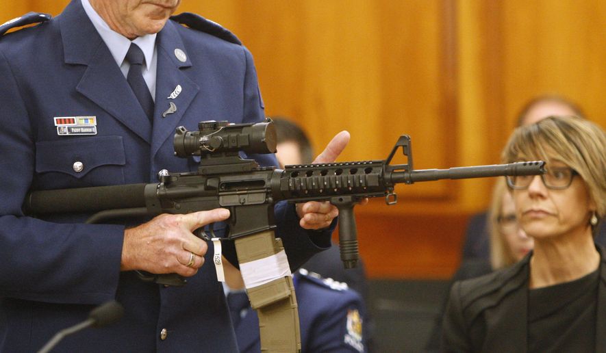 FILE - In this April 2, 2019, file photo, Police Sr. Sgt. Paddy Hannan shows New Zealand lawmakers an AR-15 style rifle similar to one of the weapons a gunman used to slaughter 50 people at two mosques, in Wellington, New Zealand. Dozens of Christchurch gun owners handed over their weapons in exchange for cash in the first of more than 250 planned buyback events around New Zealand after the government outlawed many types of semi-automatics. New Zealand lawmakers in April rushed through new legislation to ban so-called military-style weapons after a lone gunman killed 51 people at two Christchurch mosques in March. (AP Photo/Nick Perry, Fie)