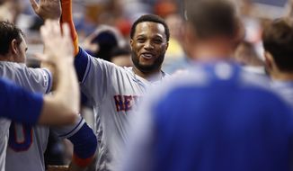New York Mets&#x27; Robinson Cano (24) celebrates in the dugout after scoring during the fourth inning of a baseball game against the Miami Marlins on Sunday, July 14, 2019, in Miami. (AP Photo/Brynn Anderson)