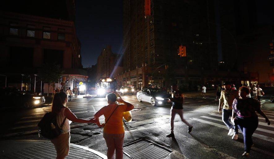 Pedestrians cross a dark street during a power outage in New York on Saturday, July 13, 2019. (AP Photo/Michael Owens) **FILE**