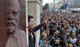 Russian opposition candidate Russian and activist Ilya Yashin, center, gestures while speaking to a crowd next to a bas-relief of the Soviet founder Vladimir Lenin, left, during a protest in Moscow, Russia, Sunday, July 14, 2019. Opposition candidates who run for seats in the city legislature in September&#39;s elections have complained that authorities try to bar them from the race by questioning the validity of signatures of city residents they must collect in order to qualify for the race. (AP Photo/Pavel Golovkin)
