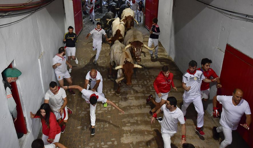 Revellers run next to fighting bulls during the running of the bulls at the San Fermin Festival, in Pamplona, northern Spain, Sunday, July 14, 2019. The San Fermin fiesta made internationally famous by Ernest Hemingway in his novel &amp;quot;The Sun Also Rises&amp;quot; draws around 1 million partygoers each year.(AP Photo/Alvaro Barrientos)