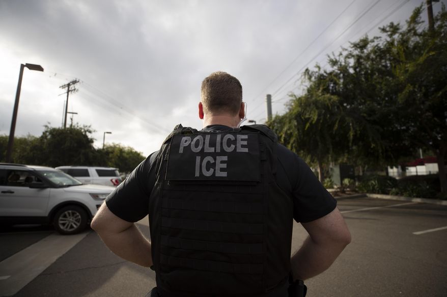 In this July 8, 2019, photo, a U.S. Immigration and Customs Enforcement (ICE) officer looks on during an operation in Escondido, Calif. The carefully orchestrated arrest last week in this San Diego suburb illustrates how President Donald Trump's pledge to start deporting millions of people in the country illegally is virtually impossible with ICE's budget and its method of picking people up. (AP Photo/Gregory Bull) **FILE**