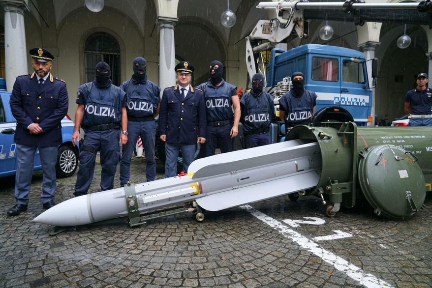 Police stand by a missile seized at an airport hangar near Pavia, northern Italy, following an investigation into Italians who took part in the Russian-backed insurgency in eastern Ukraine, in Turin, Italy, Monday, July 15, 2019. Police in northern Italy have detained three men, including one tied to a neo-fascist Italian political party, after uncovering a huge stash of automatic weapons, a missile and Nazi propaganda. (Tino Romano/ANSA via AP)