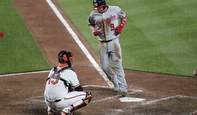 Washington Nationals&#x27; Brian Dozier (9) touches home in front of Baltimore Orioles catcher Chance Sisco (15) after Dozier was awarded home plate on a balk by relief pitcher Shawn Armstrong during the sixth inning of a baseball game Tuesday, July 16, 2019, in Baltimore. The Nationals won 8-1. (AP Photo/Julio Cortez) ** FILE **