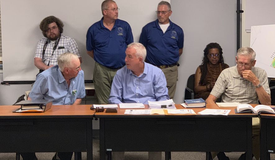 Members of the Vernon, N.Y., Planning Board are seated at the table at Vernon Town Hall, in Vernon, N.Y., Tuesday, July 16, 2019. According to the Utica Observer-Dispatch, the planning board denied a permit to Woodstock 50 organizers for a second time as they sought to hold a music festival at a local horse track in August. (Edward Harris/Observer-Dispatch via AP)