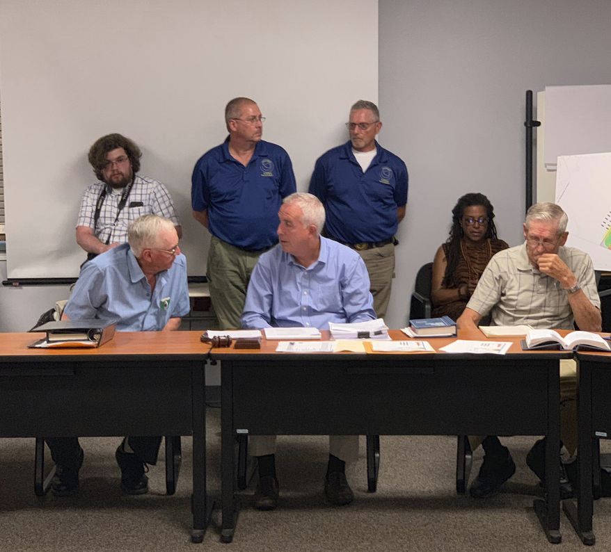 Members of the Vernon, N.Y., Planning Board are seated at the table at Vernon Town Hall, in Vernon, N.Y., Tuesday, July 16, 2019. According to the Utica Observer-Dispatch, the planning board denied a permit to Woodstock 50 organizers for a second time as they sought to hold a music festival at a local horse track in August. (Edward Harris/Observer-Dispatch via AP)