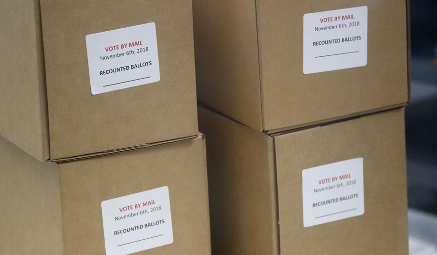 FILE - In this Wednesday, Nov. 14, 2018, file photo, boxes for recounted ballots are stacked at the Broward County Supervisor of Elections office during a recount, in Lauderhill, Fla. A federal judge in Florida has begun hearing arguments over a state law that would automatically place President Donald Trump at the top of the 2020 presidential ballot. (AP Photo/Wilfredo Lee, File)
