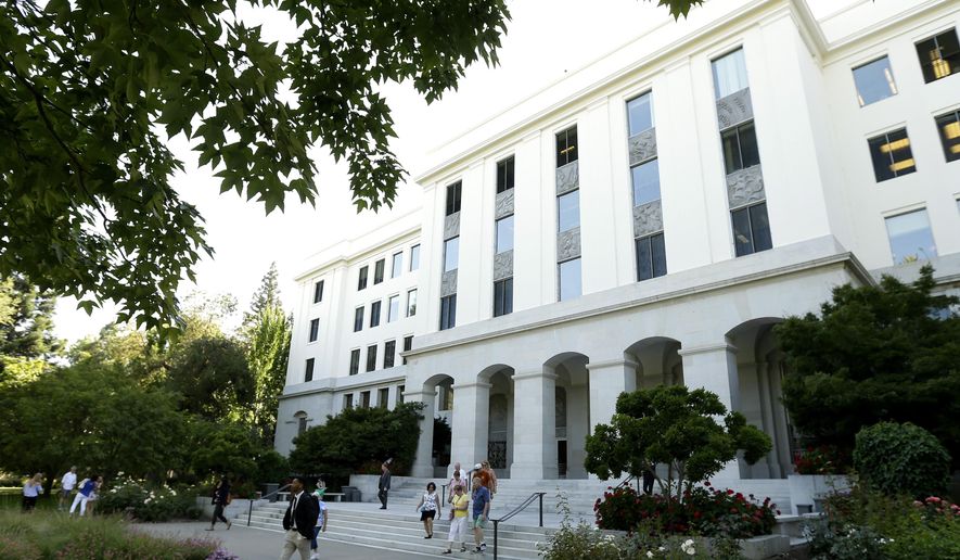 FILE - In this June 14, 2018, file photo, people leave the office building attached to the state Capitol in Sacramento, Calif. A new report on Tuesday, July 16, 2019, by California's state auditor is raising concerns about information security at government agencies that do not fall under the standards of the state's department of technology. (AP Photo/Rich Pedroncelli, File)