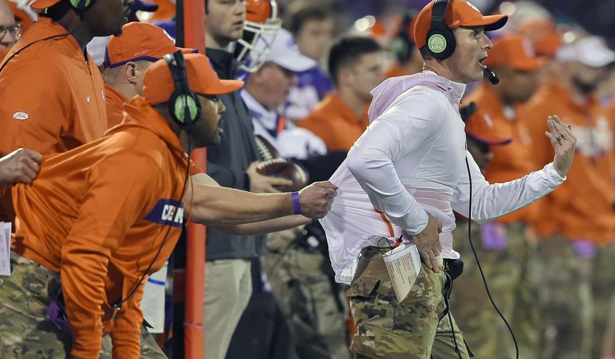 FILE - In this Nov. 17, 2018, file photo, Clemson defensive coach Brent Venables is pulled back by an assistant during the first half of an NCAA college football game in Clemson, S.C. Clemson’s defense was a big reason why the Tigers won a second national championship in three seasons. Now that unit has massive holes to fill after losing its entire front to the NFL, along with three key linebackers and two members of the secondary _ and that could mean the Tigers have to win shootouts behind quarterback Trevor Lawrence to stay on top. (AP Photo/Richard Shiro, File)